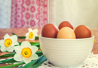 Image showing Easter eggs in a ceramic vase and flowers daffodils.