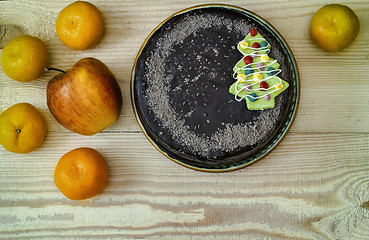 Image showing Chocolate cake and fruit: apples and tangerines.