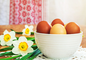 Image showing Easter eggs in a ceramic vase and flowers daffodils.