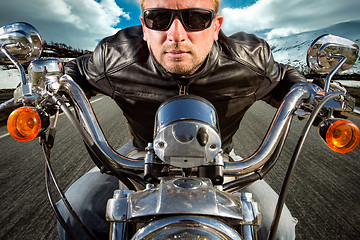 Image showing Funny Biker in sunglasses and leather jacket racing on mountain 