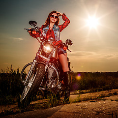 Image showing Biker girl sitting on motorcycle