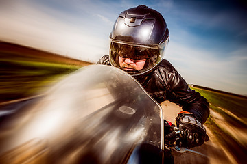 Image showing Biker racing on the road