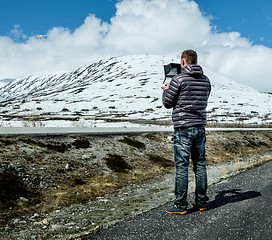 Image showing Pilot controls the drone performing flight over the mountains