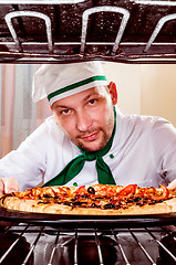 Image showing Chef cooking pizza in the oven.