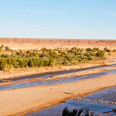 Image showing sunset in africa old construction near the river blue