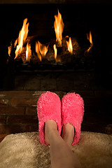 Image showing Warming feet by the fire