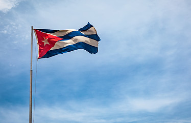 Image showing Cuban flag flying in the wind on a backdrop of blue sky.