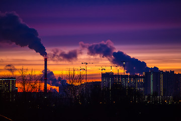 Image showing Modern city in the evening at sunset. Smoke comes out of the pip