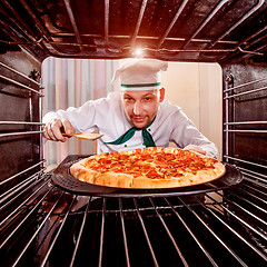 Image showing Chef cooking pizza in the oven.