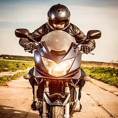 Image showing Biker racing on the road