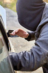 Image showing Hooligan breaking into car