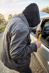 Image showing Hooligan breaking into car