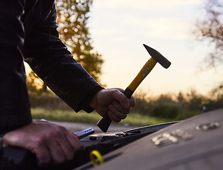 Image showing Hooligan breaking into car