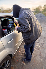 Image showing Hooligan breaking into car