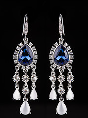 Image showing earring with colorful blue gems on black background