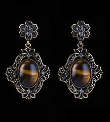 Image showing bronze earrings with jewels on the black