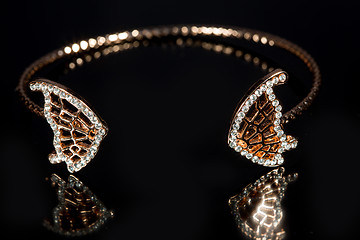 Image showing gold bracelet on black background. 