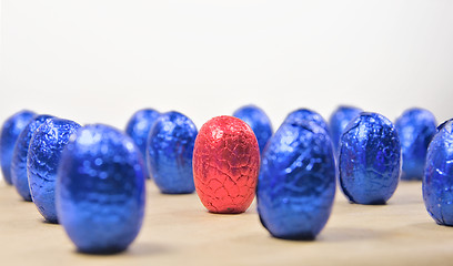 Image showing one red easter egg in rows of blue eggs