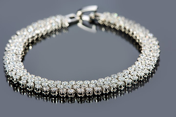 Image showing golden bracelet with precious stones on grey background