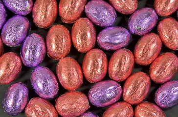 Image showing collection of salmon pink and purple easter eggs as background