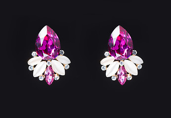 Image showing earring with colorful pink gems on black background