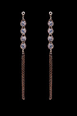 Image showing gold earrings with jewels on the black