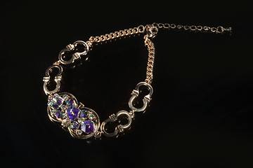 Image showing golden bracelet with precious stones on black background