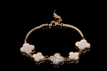 Image showing gold bracelet on black background. 