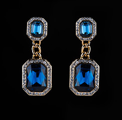 Image showing earring with colorful blue gems on black background