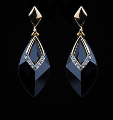 Image showing earring with colorful black gems on black background