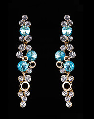 Image showing earring with colorful blue gems on black background