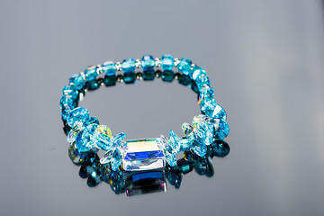 Image showing beautiful blue bracelet on gray background. 