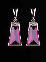 Image showing earring with colorful pink gems on black background