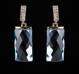 Image showing earring with colorful blue gems on black background