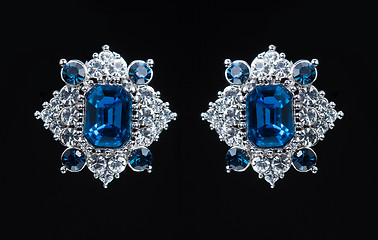 Image showing earring with colorful blue gems on black background