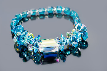 Image showing beautiful blue bracelet on gray background. 