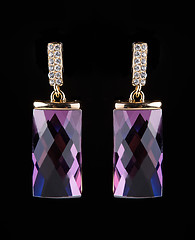 Image showing earring with colorful pink gems on black background