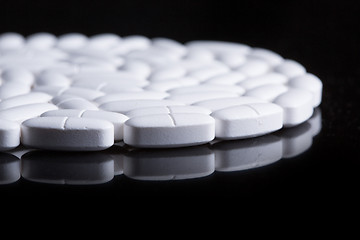 Image showing White pills on the black