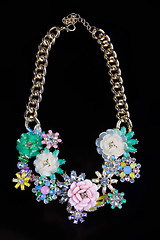 Image showing luxury necklace of plastic flowers on black stand