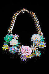 Image showing luxury necklace of plastic flowers on black stand