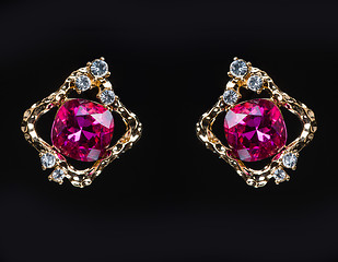 Image showing earring with colorful pink gems on black background