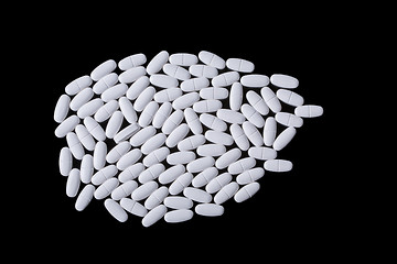 Image showing White pills on the black