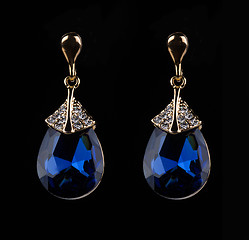 Image showing earring with colorful blue gems on black background