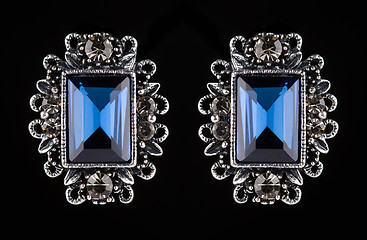 Image showing earring with colorful blue gems on black background