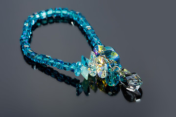 Image showing beautiful blue bracelet on gray background. 