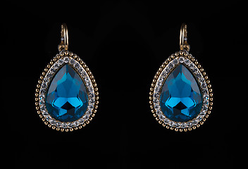 Image showing earring with colorful blue gems on black background