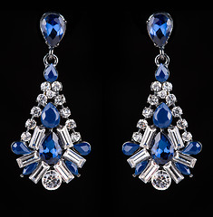 Image showing earring with colorful blue gems on black background