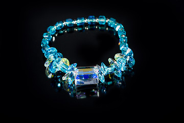 Image showing beautiful blue plastic bracelet on black background. 