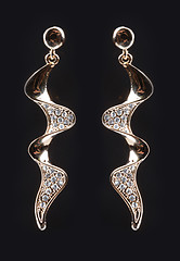 Image showing gold earrings with jewels on the black