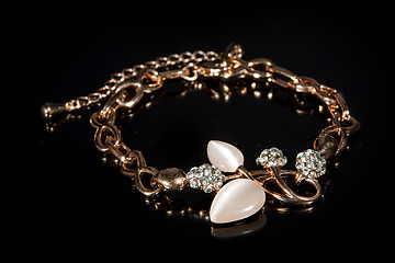 Image showing gold bracelet on black background. 